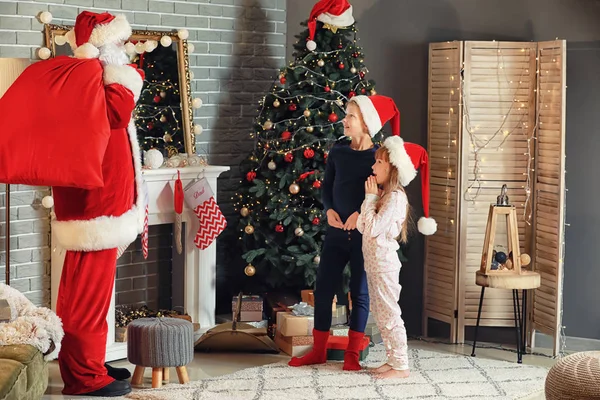 Crianças encontrando Papai Noel na sala de estar decorada para o Natal — Fotografia de Stock