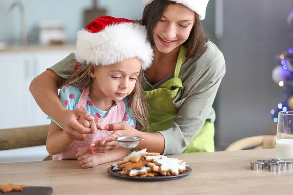 Woman and her little daughter preparing Christmas cookies at home — Stock Photo, Image