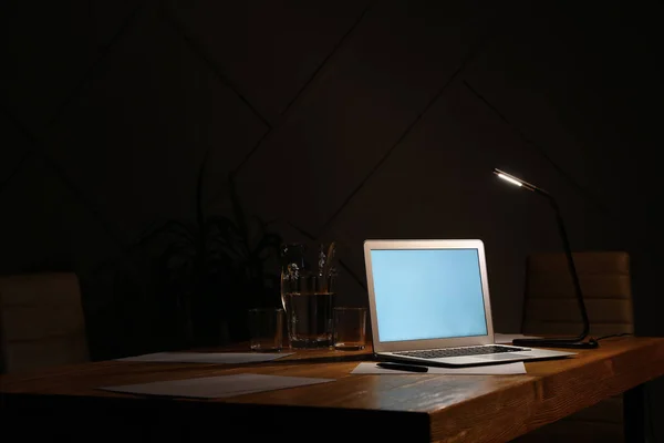 Modern workplace with laptop in evening — Stock Photo, Image