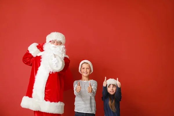 圣诞老人和小孩在色彩背景上竖起大拇指 — 图库照片
