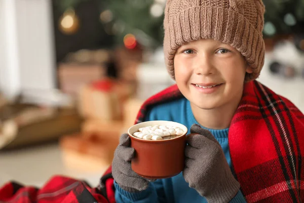 Bonito menino bebendo chocolate quente em casa na véspera de Natal — Fotografia de Stock