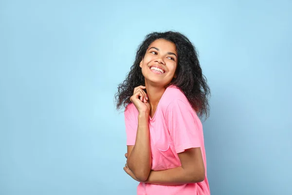 Heureuse jeune femme afro-américaine sur fond de couleur — Photo