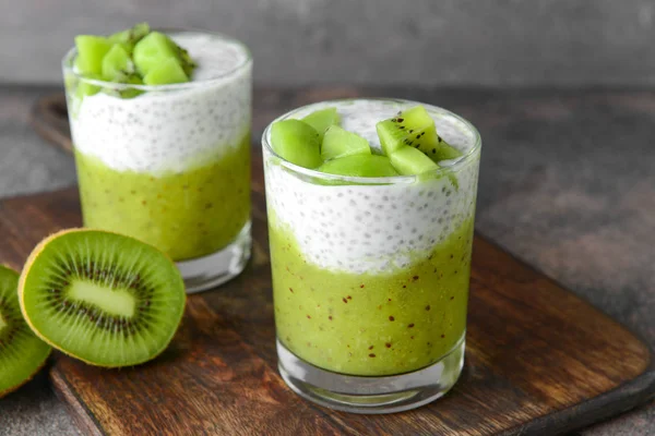 Glasses with tasty kiwi dessert on wooden board — Stock Photo, Image