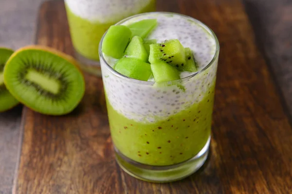 Glass with tasty kiwi dessert on wooden board — Stock Photo, Image