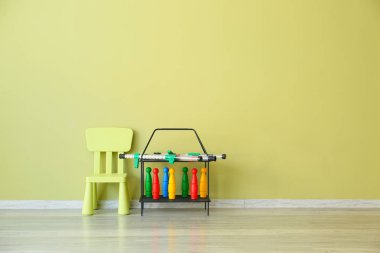 Çocuk odasında renkli duvara yakın masa ve oyuncaklar ile sandalye