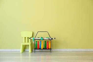 Çocuk odasında renkli duvara yakın masa ve oyuncaklar ile sandalye