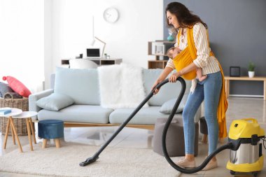 Küçük bebek evde işleri yapıyor genç anne