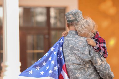 Military man hugging his little daughter outdoors clipart