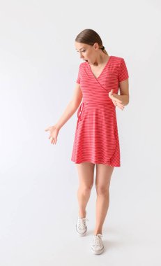 Beyaz arka planda şok olmuş genç bir kadın.