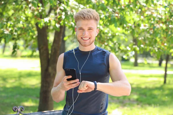 Sporty young man checking his pulse outdoors — Stock Photo, Image