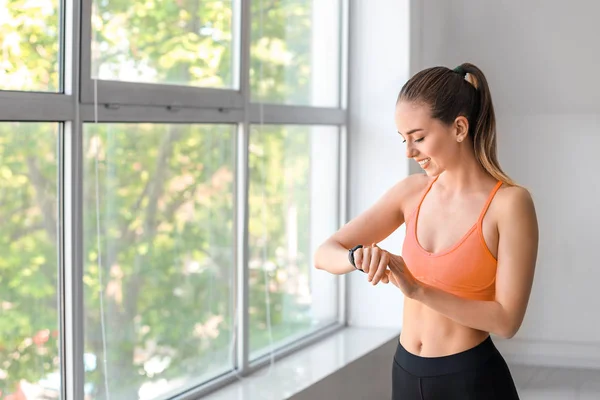 Sporty young woman checking her pulse after training in gym — Stock Photo, Image
