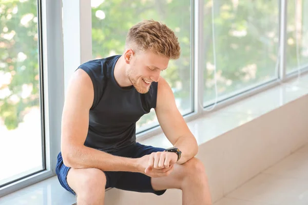 Sporty young man checking his pulse after training in gym — Stock Photo, Image