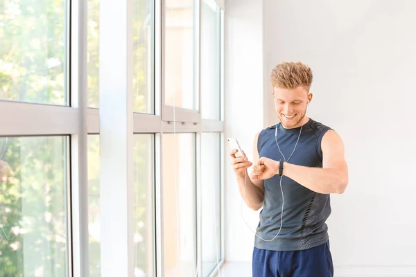 Sporty young man checking his pulse after training in gym — Stock Photo, Image