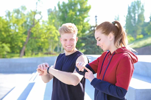 Sportieve jonge mensen controleren hun hartslag buitenshuis — Stockfoto