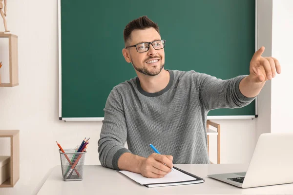 Handsome male teacher calling out pupil during lesson in classroom — Stock Photo, Image