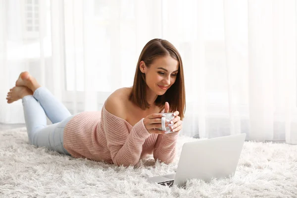 Mulher bonita com laptop bebendo chá em casa — Fotografia de Stock