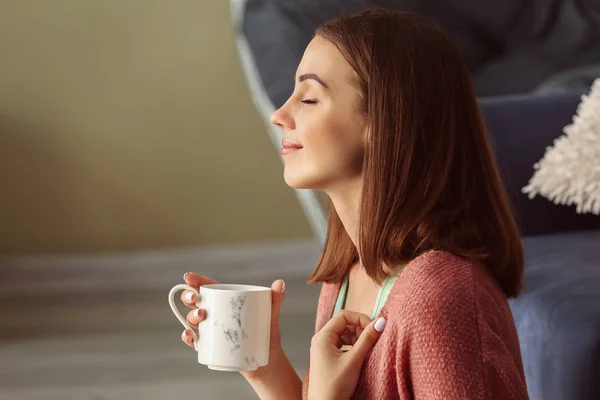 Schöne junge Frau trinkt Tee zu Hause — Stockfoto