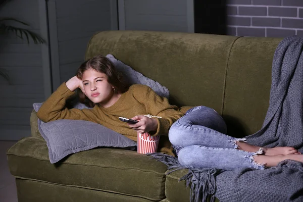 Емоційна дівчина-підліток дивиться телевізор вночі — стокове фото