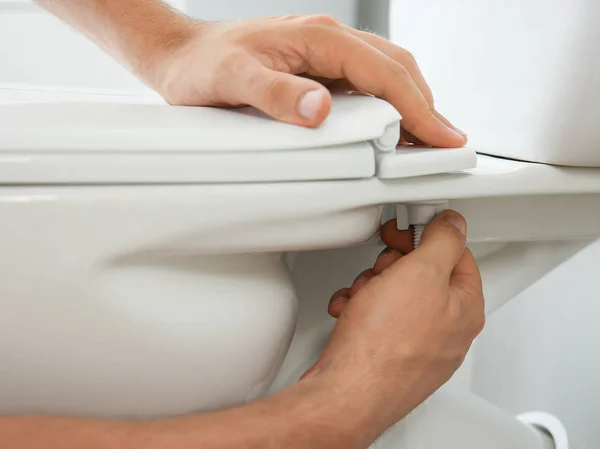 Plumber installing toilet in restroom, closeup — Stock Photo, Image