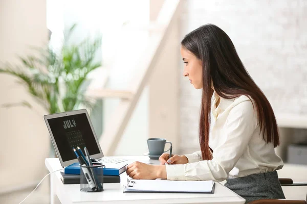 Nő használ naptár-ra laptop képernyő rövid idő működő hivatalban — Stock Fotó