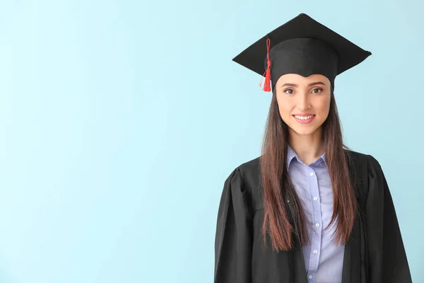 Female graduate on color background — Stock Photo, Image