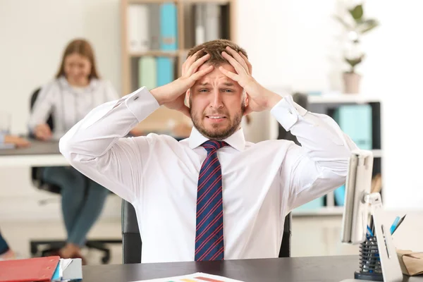 Businessman having panic attack in office