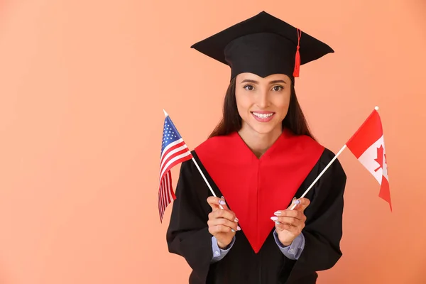 Női diplomás az USA és a kanadai zászlók színes háttér — Stock Fotó
