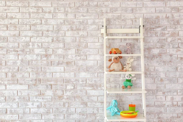Rack with toys near brick wall in children's room — Stock Photo, Image