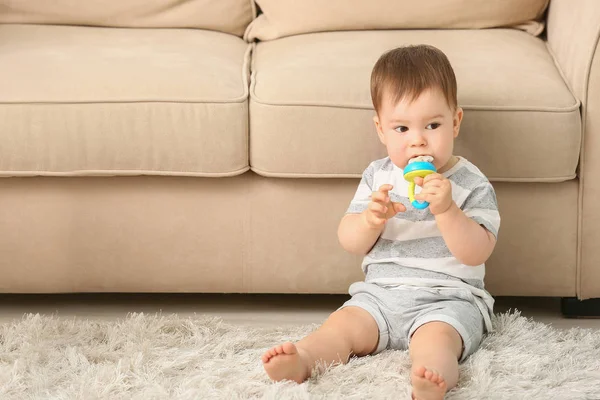 Cute little boy with nibbler sitting on floor at home — Stock Photo, Image