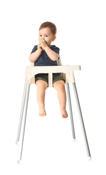 Menino bonito com nibbler sentado em cadeira alta contra fundo branco — Fotografia de Stock