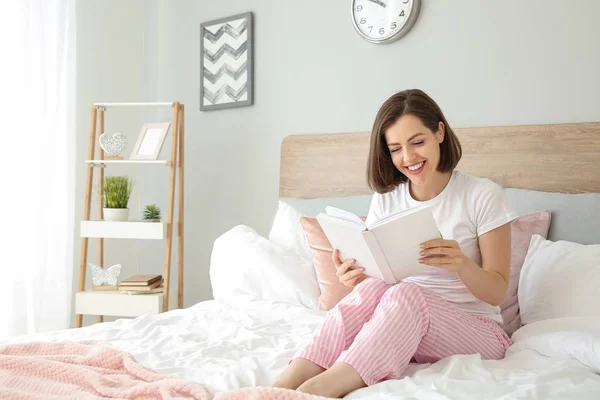 Morning of beautiful young woman reading book in bed — Stock Photo, Image