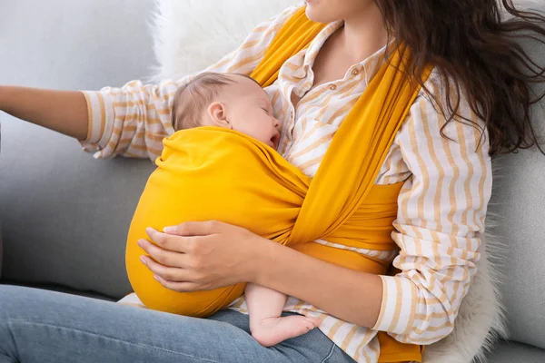 Young mother with little baby in sling at home — Stock Photo, Image