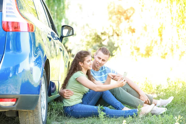 Happy young couple near car outdoors — Stock Photo, Image