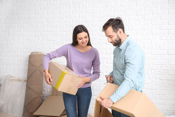 Young couple with belongings after moving into new house — Stock Photo, Image