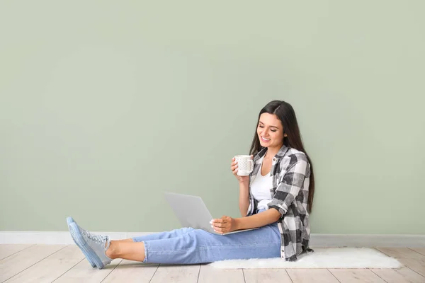Kobieta blogger z laptopem siedzi w pobliżu koloru ściany — Zdjęcie stockowe