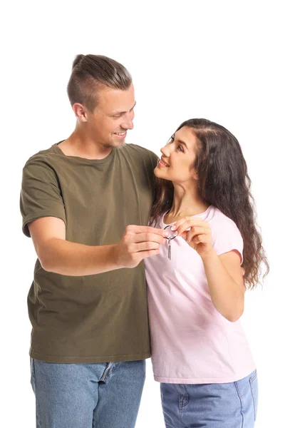 Glückliches junges Paar mit Schlüssel aus Neuwagen auf weißem Hintergrund — Stockfoto