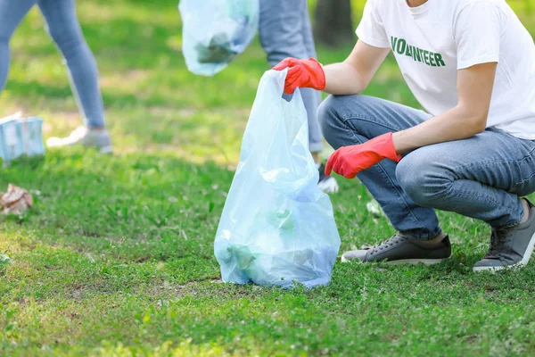 Male volunteer gathering garbage in park