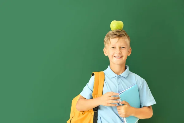 Pequeno estudante com maçã no fundo de cor — Fotografia de Stock