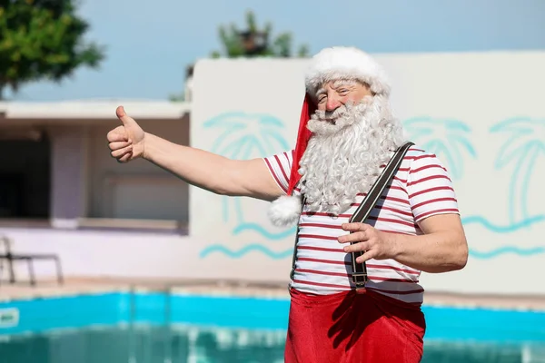 Санта-Клаус показал большой палец у бассейна на курорте — стоковое фото