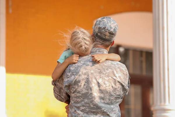 屋外で彼の小さな娘を抱きしめる軍人 — ストック写真