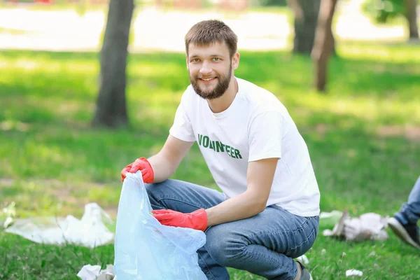 Male volunteer gathering garbage in park — Stock Photo, Image