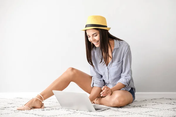 Vrouwelijke Blogger met laptop zittend in de buurt van witte muur — Stockfoto