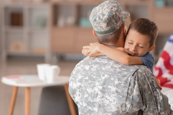 Glücklicher Militärmann, der seinen Sohn zu Hause umarmt — Stockfoto