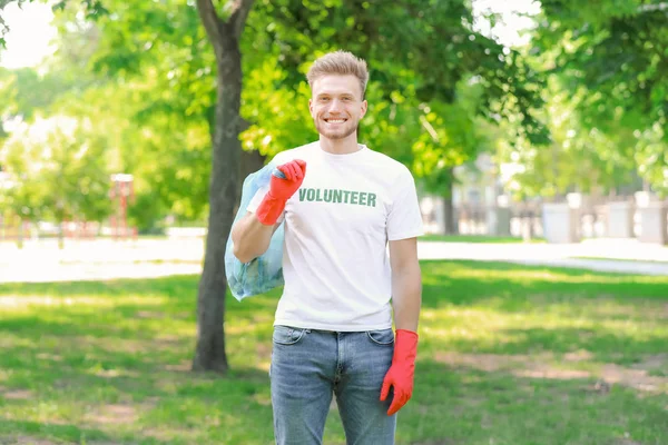 Чоловічий доброволець збирає сміття в парку — стокове фото
