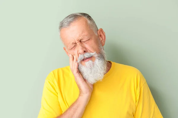 Üst düzey adam renk arka plan karşı diş ağrısı muzdarip — Stok fotoğraf