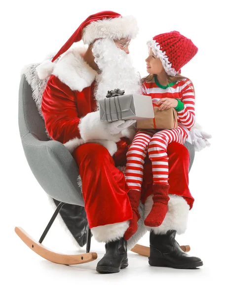 Santa Claus and little girl with gifts sitting in armchair against white background — Stock Photo, Image