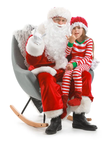 Weihnachtsmann und kleines Mädchen zeigen "Teufelshörner" -Geste, während sie im Sessel vor weißem Hintergrund sitzen — Stockfoto