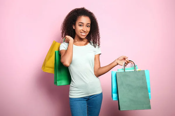 Portré boldog afro-amerikai nő bevásárló táskák színes háttér — Stock Fotó