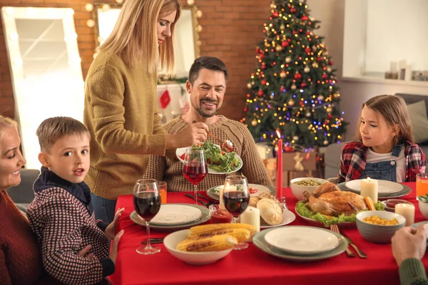 Glad familj som äter julmiddag hemma — Stockfoto