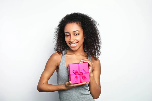 Portrait de belle femme afro-américaine avec boîte cadeau sur fond blanc — Photo